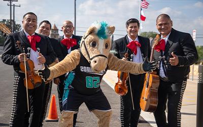 The Palo Alto College Palomino mascot poses with mariachis